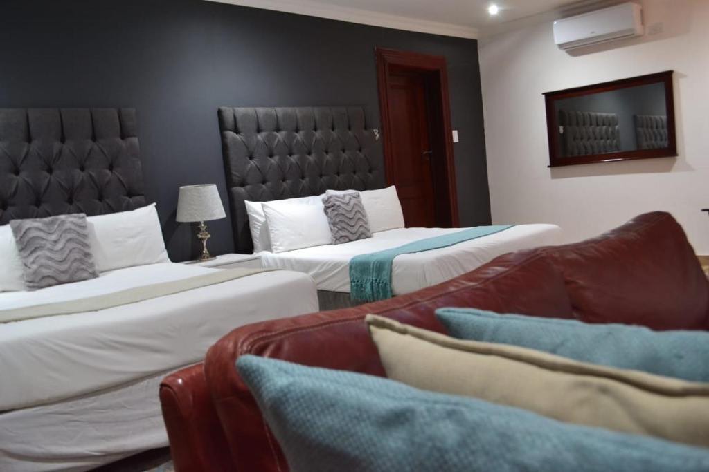 Deluxe Double or Twin room with two large beds and a leather couch